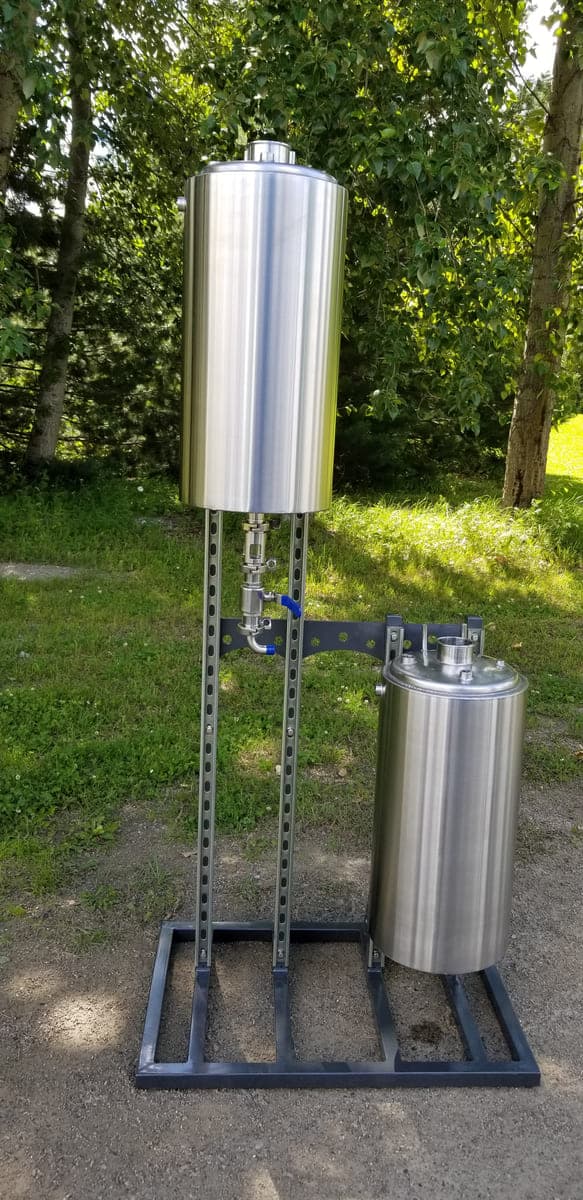Two-vessel stainless steel extraction assembly mounted on a welded steel stand